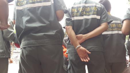 环卫工把我们紧紧围在身后，保护我们不被带走