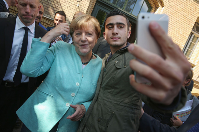 来到德国的叙利亚难民，手持iphone与德国总理默克尔自拍合影